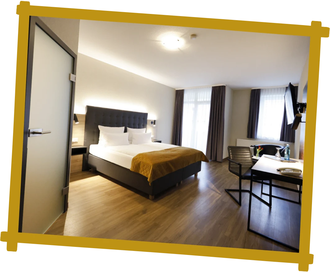 Hotelzimmer mit Doppelbett, Schreibtisch, Stuhl und großem Fenster mit Vorhängen